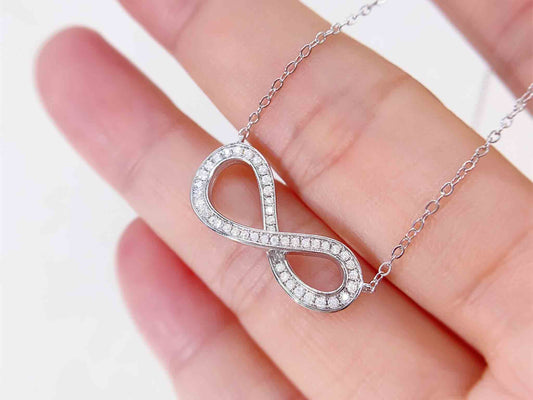 Witte ketting met infinity hanger rond gezet met briljanten