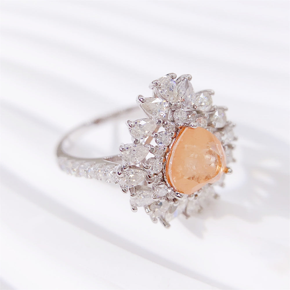 Entourage ring met een roze hart vorm, kleine briljanten, marquizen en peer vorm briljanten