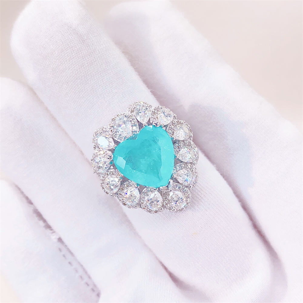 Entourage ring met een grote sky blue hartvorm briljant, kleine briljant en druppelvorm briljanten