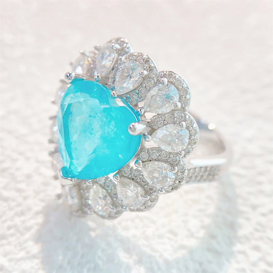 Entourage ring met een grote sky blue hartvorm briljant, kleine briljant en druppelvorm briljanten