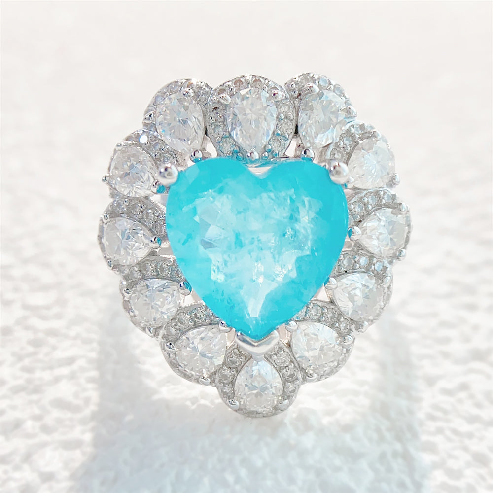 Entourage ring met een grote sky blue hartvorm briljant, kleine briljant en druppelvorm briljanten