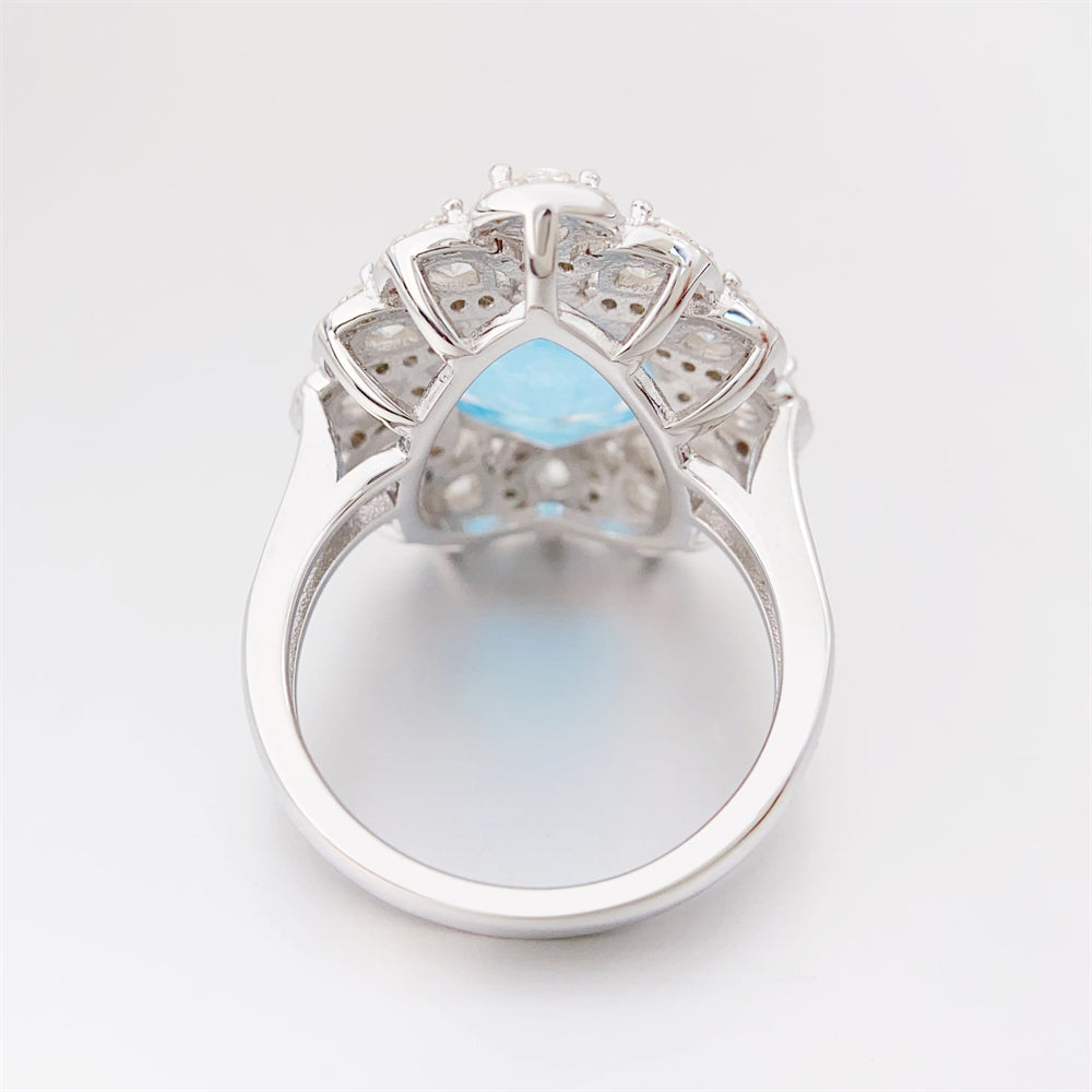 Entourage ring met een grote sky blue hartvorm briljant, kleine briljant en druppelvorm briljanten