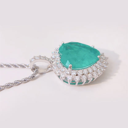 Witte hanger met een grote smaragd groen gekleurde hartvorm edelsteen en witte briljanten