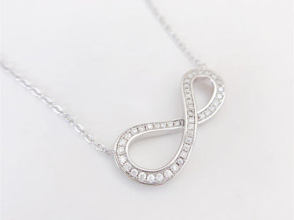 Witte ketting met infinity hanger rond gezet met briljanten