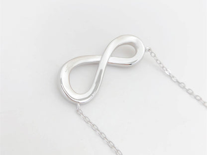 Witte ketting met infinity hanger rond gezet met briljanten