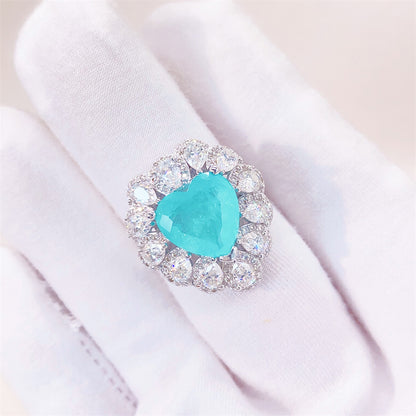 Entourage ring met een grote sky blue hartvorm briljant, kleine briljant en druppelvorm briljanten