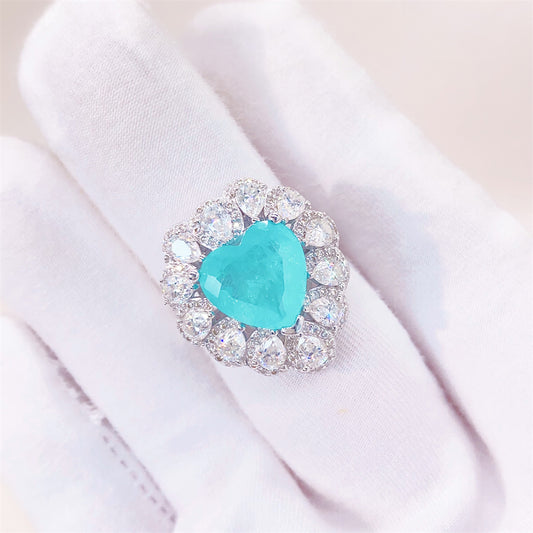 Entourage ring met een grote sky blue hartvorm briljant, kleine briljant en druppelvorm briljanten